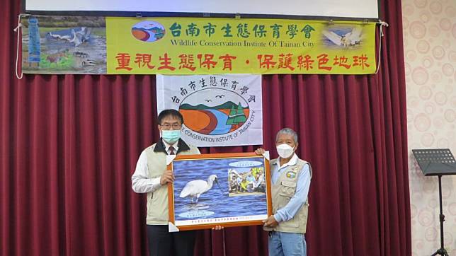 台南市生態保育學會召開年會，市長黃偉哲在會中贈匾表揚發現Ｔ85黑面琵鷺的鳥友黃永豐。（生態保育學會提供）