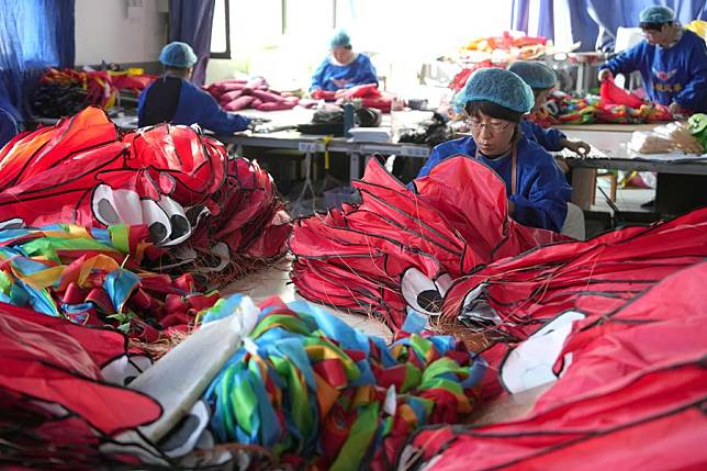 Workers make kites at a kite factory in Hanting District of Weifang, east China's Shandong Province, Oct. 14, 2024. (Xinhua/Xu Suhui)