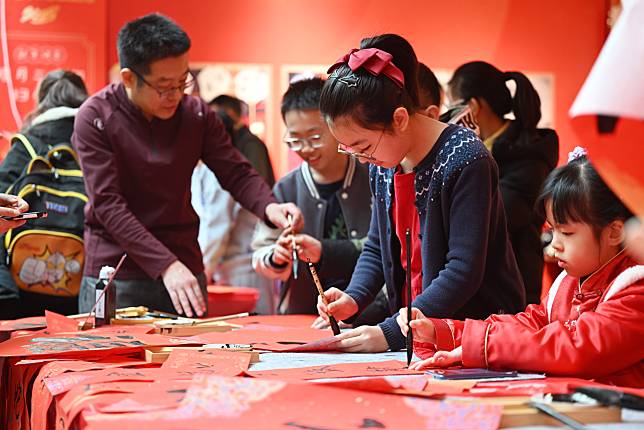 Children write Spring Festival couplets during a children's temple fair at the Youth and Children's Center in north China's Tianjin, Jan. 18, 2025. (Xinhua/Li Ran)