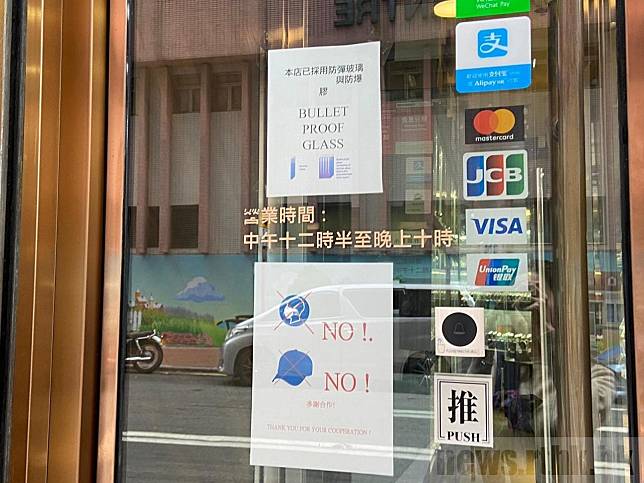 有店舖貼出告示，表示該店採用防彈玻璃和防爆膠，又禁止客人帶鴨舌帽和口罩。（陳青儀攝）