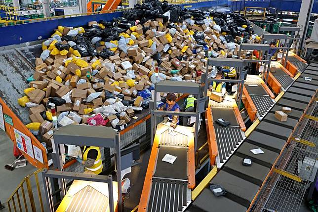 Staff members sort packages at a logistic center of Zaozhuang branch of China Post in Zaozhuang City, east China's Shandong Province, Nov. 11, 2024. Manufacturers, e-commerce platforms and logistics companies across the country are busy coping with customer's demand during China's annual &ldquo;Double 11&rdquo; shopping festival. (Photo by Sun Zhongzhe/Xinhua)