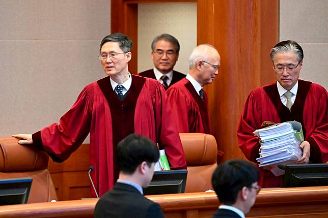 憲法法院代理院長文炯培（左）及其他法官陸續入座。美聯社
