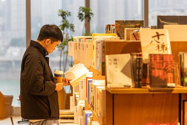 A customer reads a book at Tsutaya Bookstore in Yuzhong District of southwest China's Chongqing Municipality, Jan. 21, 2024. (Xinhua/Chu Jiayin)