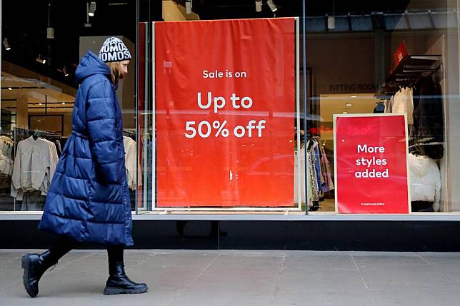 A woman walks past a sale sign displayed in a store in London, Britain, Jan. 17, 2024. (Xinhua)