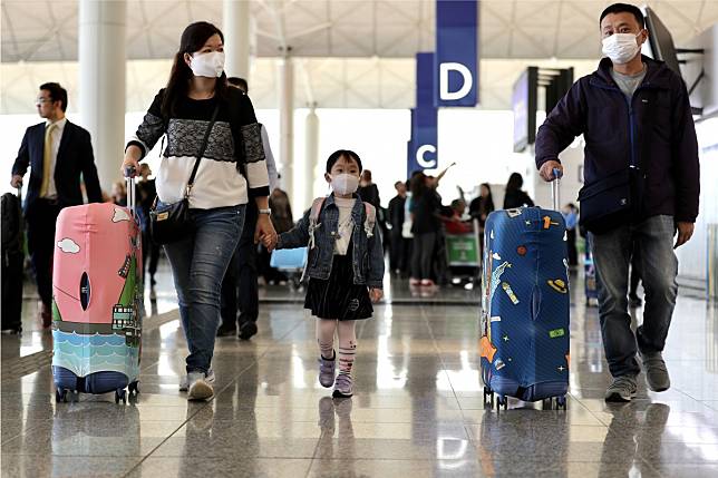 Travellers wearing face masks walk through Hong Kong International Airport on Wednesday as the coronavirus spreads globally. Photo: Bloomberg