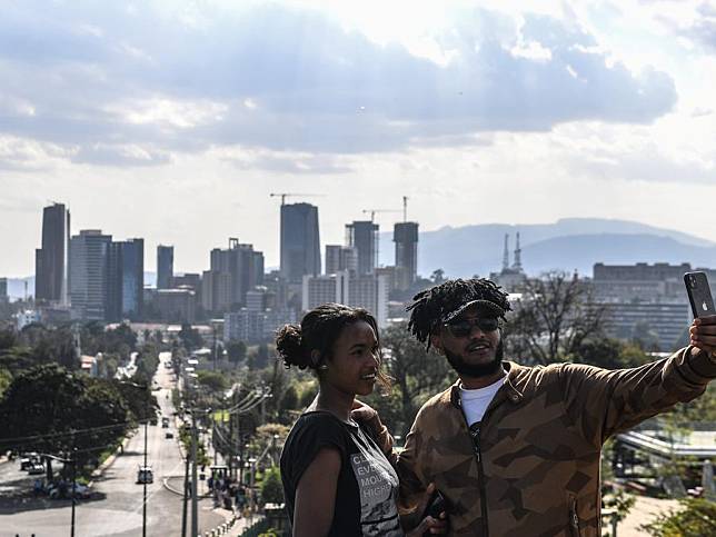 Tourists take a selfie with the city view of Addis Ababa, Ethiopia, Feb. 18, 2024. (Xinhua/Li Yahui)