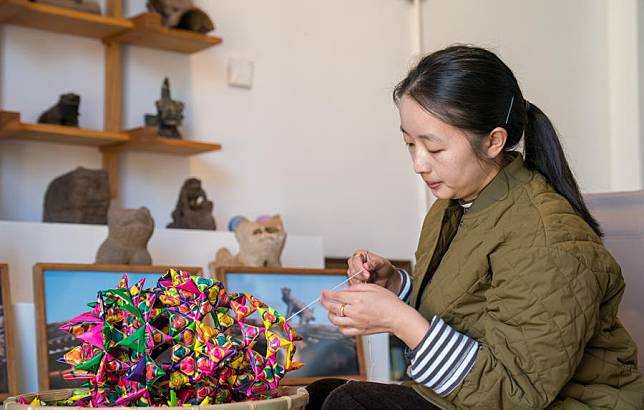 Yang Jie makes a rhombic straw plaited work at her studio in Kunming, southwest China's Yunnan Province, Jan. 25, 2025. (Photo by Peng Yikai/Xinhua)