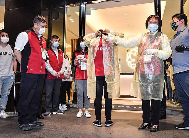 台北市長柯文哲（前左）6日晚間視察台北市防疫旅館 ，觀看旅館防疫人員示範穿上隔離衣。 中央社記者鄭清元攝　110年5月6日  
