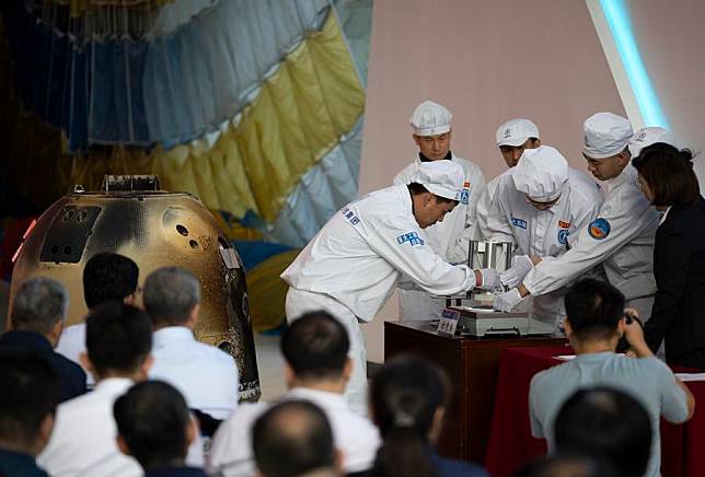 Researchers weigh the Chang'e-6 lunar samples during a returner opening ceremony at the China Academy of Space Technology under the China Aerospace Science and Technology Corporation in Beijing, capital of China, June 26, 2024. China's Chang'e-6 mission collected 1,935.3 grams of samples from the far side of the moon, the China National Space Administration (CNSA) announced Friday. Zhang Kejian, head of the CNSA, handed over the sample container to Ding Chibiao, vice president of the Chinese Academy of Sciences (CAS), along with the sample certificate at a ceremony held in Beijing. Minister of Industry and Information Technology Jin Zhuanglong presided over the handover ceremony. (Xinhua/Jin Liwang)