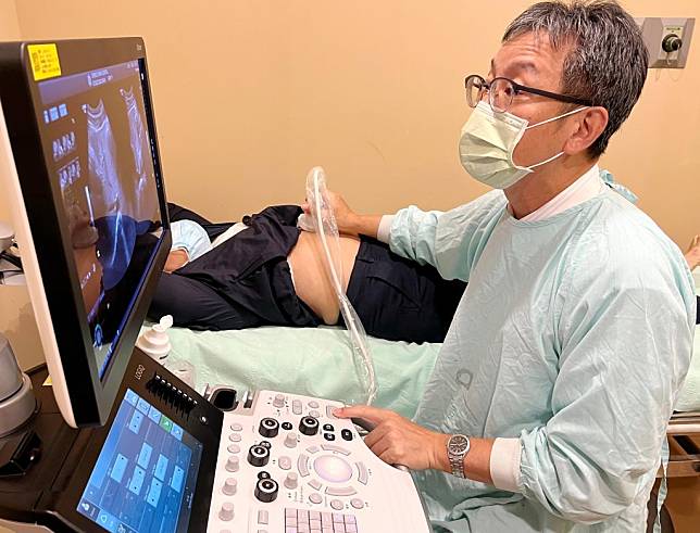 澄清醫院中港院區醫療副院長黃仁杰，為患者進行超音波腹超檢查。（記者陳金龍攝）