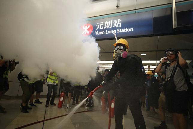A protester sets off a fire extinguisher at Yuen Long MTR station. Photo: Winson Wong