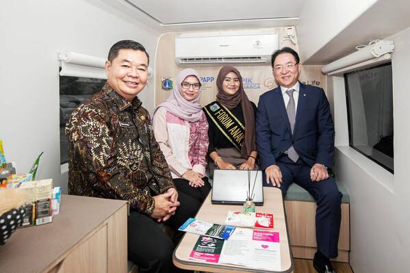 Inside the “Mobile Family Center” vehicle, Teguh Setyabudi, Acting Governor of Jakarta, Indonesia (left), and Hong Jeong-pyo, Vice President of Hanwha Life (right), pose for a commemorative photo with counselor and beneficiary child.