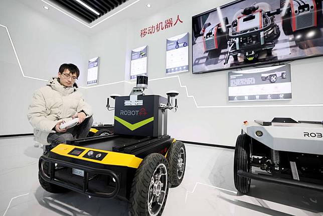 A technician adjusts an intelligent robot at a company in Yaohai District, Hefei, east China's Anhui Province, Nov. 16, 2023. (Photo by Xie Chen/Xinhua)