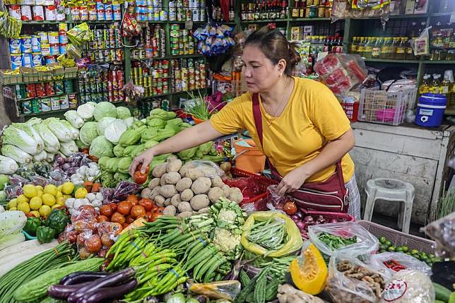 A vendor prepares vegetables at a market in Quezon City, the Philippines, Aug. 6, 2024. (Xinhua/Rouelle Umali)