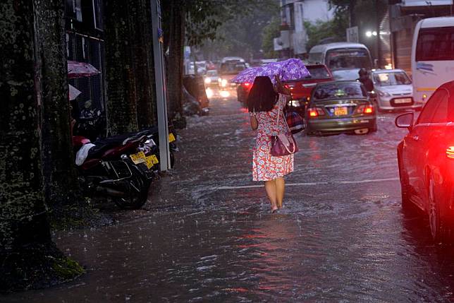 A pedestrian walks on a flooded street in Colombo, Sri Lanka, Nov. 26, 2024. (Photo by Gayan Sameera/Xinhua)