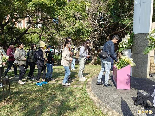 新竹市府今天在228公園舉辦228追思音樂會，參與者也手持百合花上前獻花，籲記取歷史傷痛與教訓。(記者洪美秀攝)