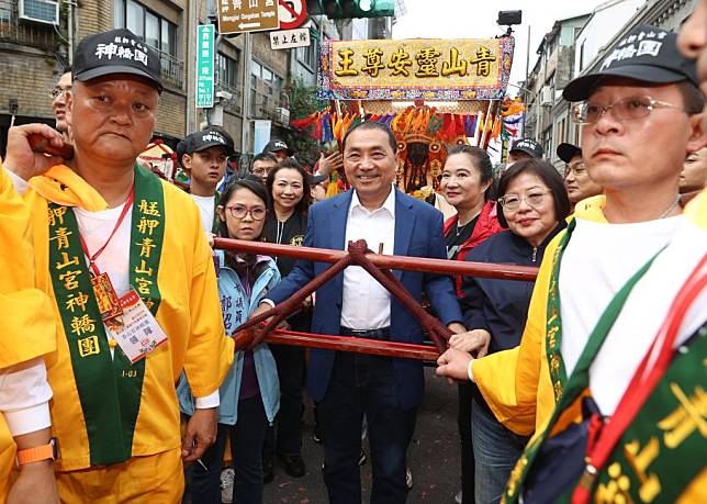 國民黨總統參選人侯友宜（中）三日下午現身台北市萬華區，參加「艋舺青山宮靈安尊王聖誕夜巡暗訪」活動，並親自扶轎。（中央社）