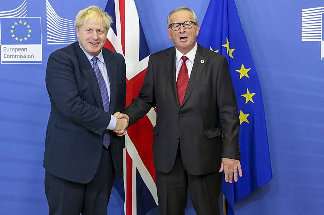 Boris Johnson, UK prime minister, left, shakes hands with Jean-Claude Juncker, president of the European Commission. Photo: Bloomberg