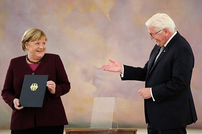 德國總理梅克爾（Angela Merkel）當地時間  10 月 26 日正式卸任，德國總統史坦麥爾（Frank-Walter Steinmeier）親自遞上解僱證書。   圖：達志影像/美聯社