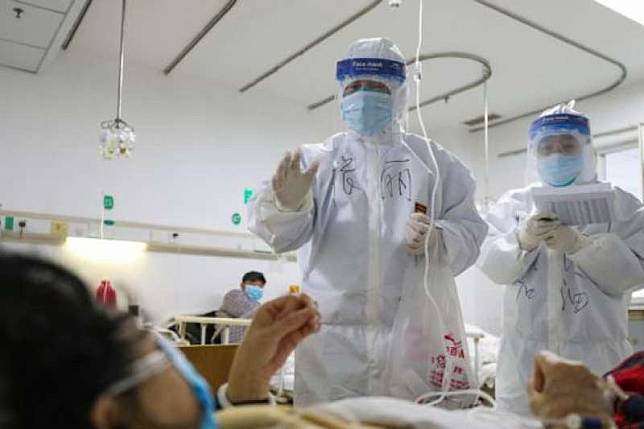 武漢金銀潭醫院的醫護人員正在檢查一名新冠肺炎患者的身體狀況。（BBC中文網／GETTY IMAGES）