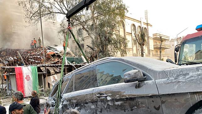 伊朗駐敘利亞大馬士革領事館4月1日被空襲炸成廢墟，瓦礫堆中還倒臥著伊朗國旗旗桿。路透社