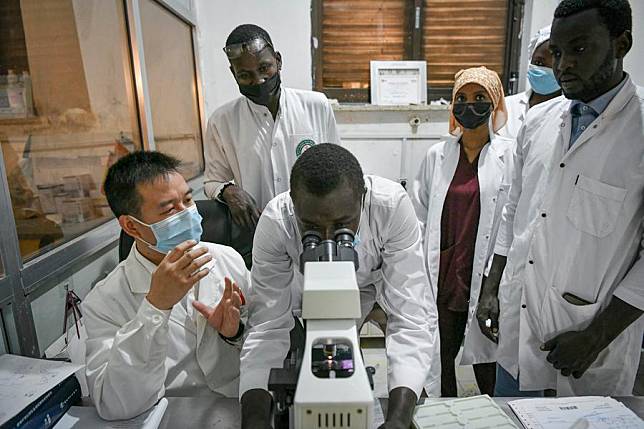 Chinese doctor Wang Zhi, a member of the 20th Chinese medical team to Chad, helps local medical staff with histopathological section diagnosis at the China-Chad Friendship Hospital in N'Djamena, Chad, Jan. 9, 2025. (Xinhua/Han Xu)