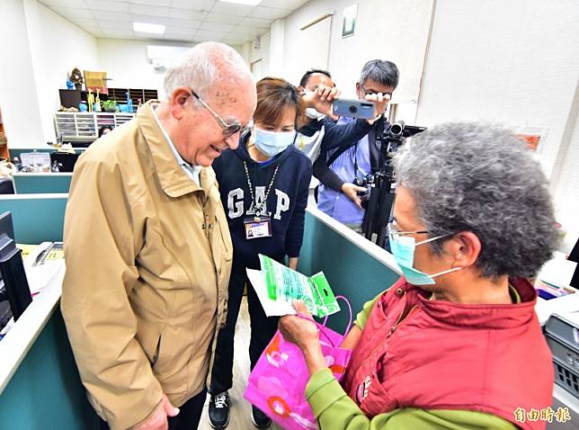 83歲何姓婦人，捐出自己辛苦排隊而來的口罩，以及1天賣菜所得，親手交給神父呂若瑟，「這是我的一點小心意。」(記者張議晨攝)