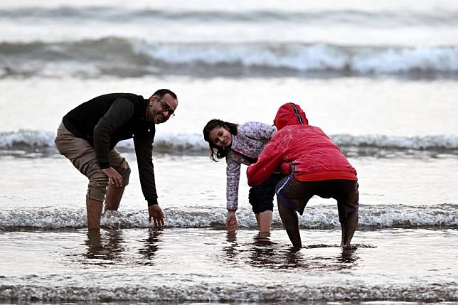 People pose for a photo on a beach in southern Pakistani port city of Karachi on Dec. 26, 2024. (Xinhua/Ahmad Kamal)