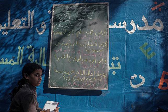 A Palestinian student is seen outside a tent that was turned into a small classroom to educate displaced children at a temporary shelter in Deir al-Balah central Gaza Strip, on Jan 6, 2025. (Photo by Rizek Abdeljawad/Xinhua)