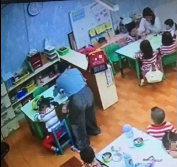 家長質疑，幼兒園教師站在女童背後，疑似用不當方式對女童強行餵藥。(民眾提供)