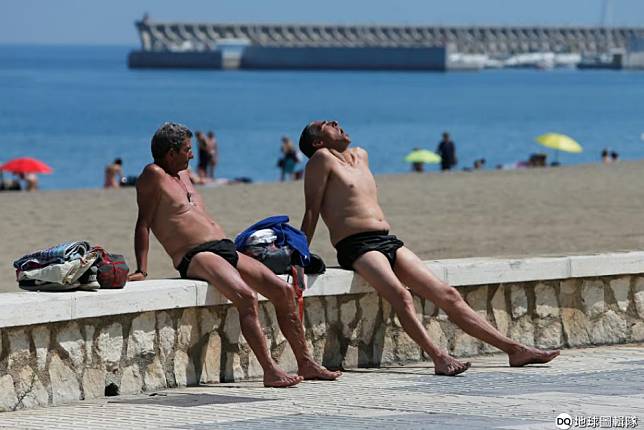 在西班牙南部馬拉加（Malaga）海灘上，兩名男子正在享受豔陽的洗禮。 路透社