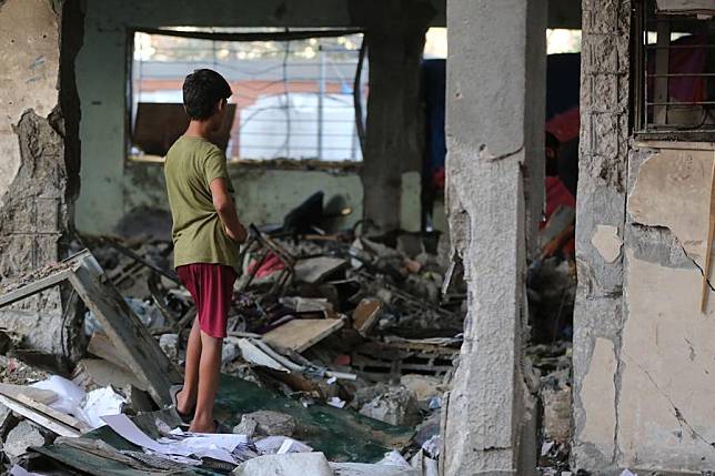 A Palestinian boy checks the damage at Rafida School destroyed in an Israeli airstrike in the city of Deir al-Balah, central Gaza Strip, on Oct. 11, 2024. (Photo by Marwan Dawood/Xinhua)