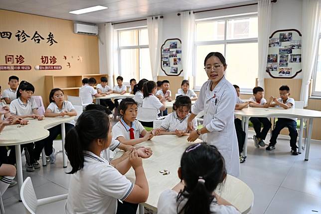 Students learn about traditional Chinese medicine knowledge at a primary school in Xiong'an New Area, north China's Hebei Province, May 22, 2024. (Xinhua/Mu Yu)