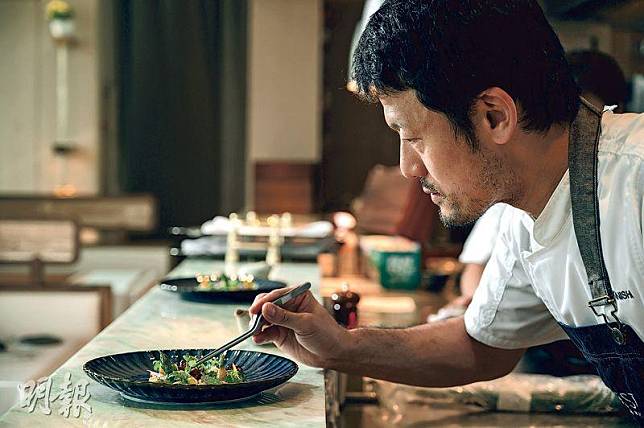 巧製前菜——Mitsuru Konishi站在開放式廚房內，把嫩葉、蔬食、花兒逐一置於碟內，創作出一片有如綠色園林的前菜。（蘇智鑫攝）