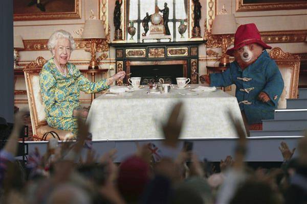 伊麗莎白二世與柏靈頓熊一起喝下午茶，並且公開她的手提包裡到底有什麼。（圖片來源／美聯社）