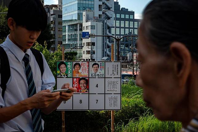 People walk past a billboard for the ongoing election campaign in Tokyo, Japan, Oct. 15, 2024.(Xinhua/Zhang Xiaoyu)