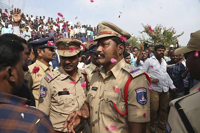 印度26歲女獸醫芮迪遭4名男子性侵並放火殺害，警方帶著4名嫌犯回到事發地點，竟當場將他們擊斃，圖為群眾為警方吶喊叫好。（AP）