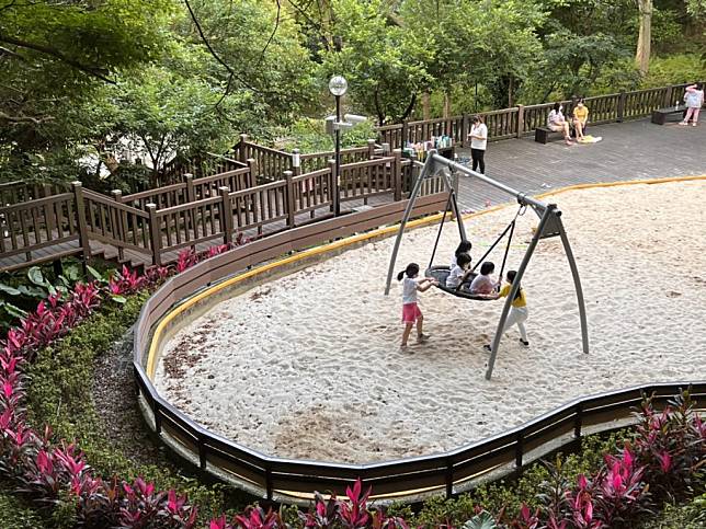 泰山辭修公園-小朋友互相協助一起玩鳥巢鞦韆。（新北市景觀處提供）
