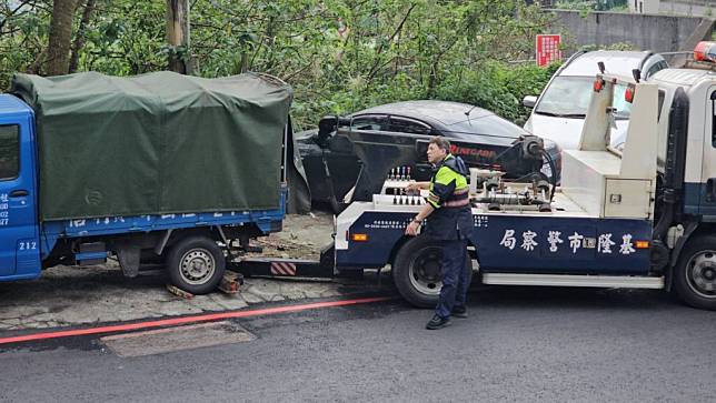 一男子疑遭殺害，被裝在冰櫃內搬運至貨車，連人帶車被棄置在基隆市信義區培德路，警方三十日尋獲運屍貨車，發現遺體已被燒成焦黑，難以辨別面容。圖為警方派員將貨車拖離現場。（中央社）