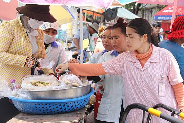 Garment factory workers buy food in Phnom Penh, Cambodia on Sept. 19, 2024. (Photo by Phearum/Xinhua)