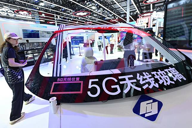 A visitor views a piece of glass equipped with 5G antenna at the hand-on experience area during the 7th Digital China Summit in Fuzhou, southeast China's Fujian Province, May 24, 2024. (Xinhua/Lin Shanchuan)