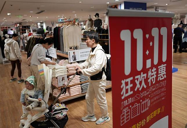 Customers walk past a banner promoting &ldquo;Double 11&rdquo; shopping festival at a store in Hangzhou, east China's Zhejiang Province, Nov. 11, 2024. (Xinhua/Han Chuanhao)