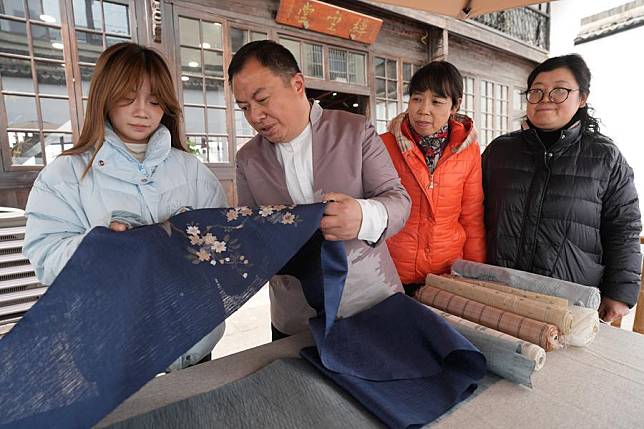 Ke Xiangxiang (2nd L) shows a piece of old Kesi work he collected to the staff members of his studio in Qianyuan Town of Deqing County, Huzhou City, east China's Zhejiang Province, Feb. 19, 2025. (Xinhua/Weng Xinyang)