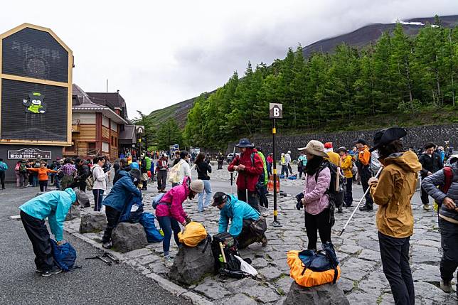 Hikers sort their bags at the Yoshida Trail of Mount Fuji in the prefecture of Yamanashi, Japan, July 1, 2024. (Xinhua/Zhang Xiaoyu)