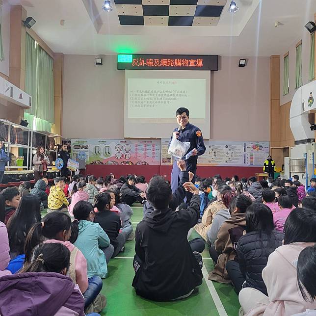 大園分局埔心派出所警員吳承殷、方顥瑾與埔心里里長盧宜芳、埔心國小的老師一同在學校的大禮堂舉辦「行人安全慢慢走、網路詐騙不要來」的宣導活動。圖：讀者提供