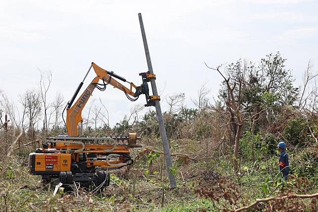 A power technician operates a machine to install an electrical wire pole in Longlou Town of Wenchang City, south China's Hainan Province, Sept. 14, 2024. (Xinhua/Zhang Liyun)