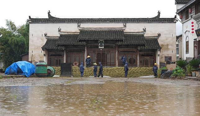 Staff members reinforce flood defence with sandbags at an old building in Chengkan Village of Huizhou District, Huangshan City, east China's Anhui Province, June 27, 2024. (Photo by Zheng Chen/Xinhua)