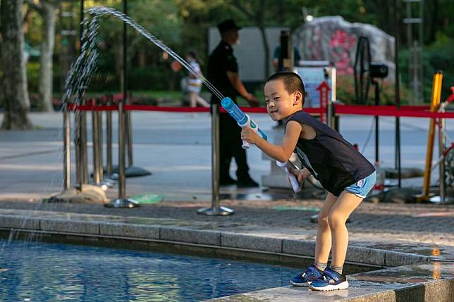 A child plays with a toy water gun at a park in Xuhui District of east China's Shanghai, July 10, 2022. (Xinhua/Wang Xiang)
