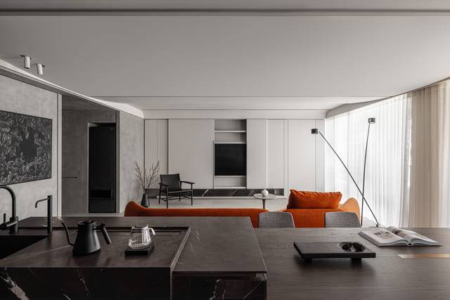 暗橘色沙發是空間中的點睛之筆，替沉穩調性注入一抹色彩，象徵業主對「藝」的探尋。