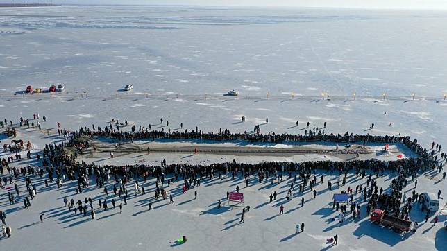 An aerial drone photo taken on Dec. 28, 2024 shows tourists watching winter fishing at Chagan Lake in Songyuan City of northeast China's Jilin Province. (Xinhua/Zhang Nan)